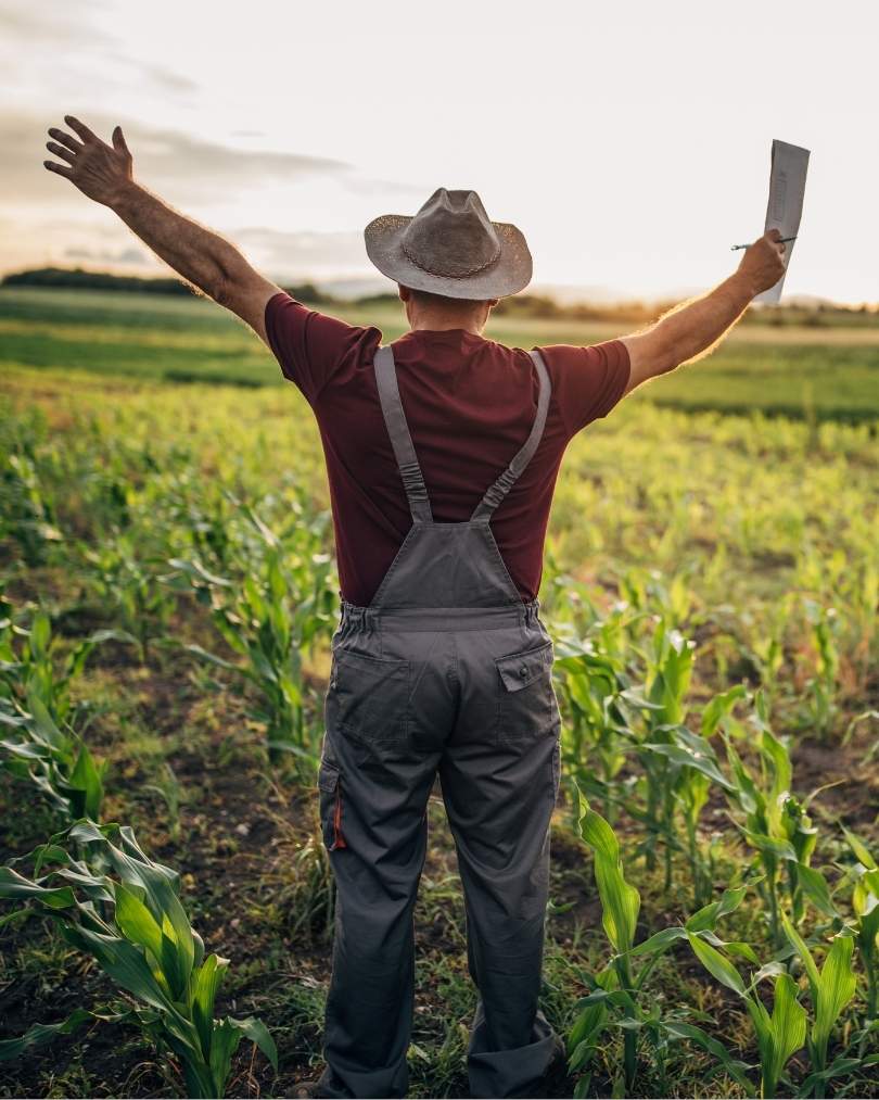 A farmer stretching hands over his farm