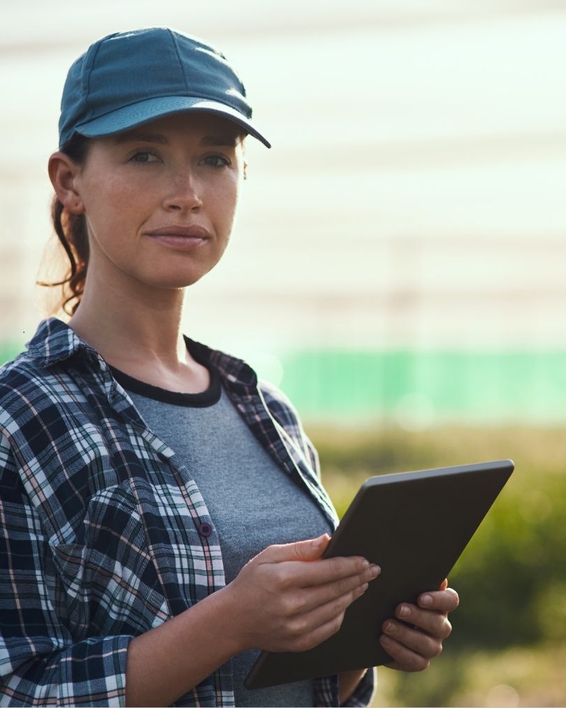 A lady in a farm holding a tablet